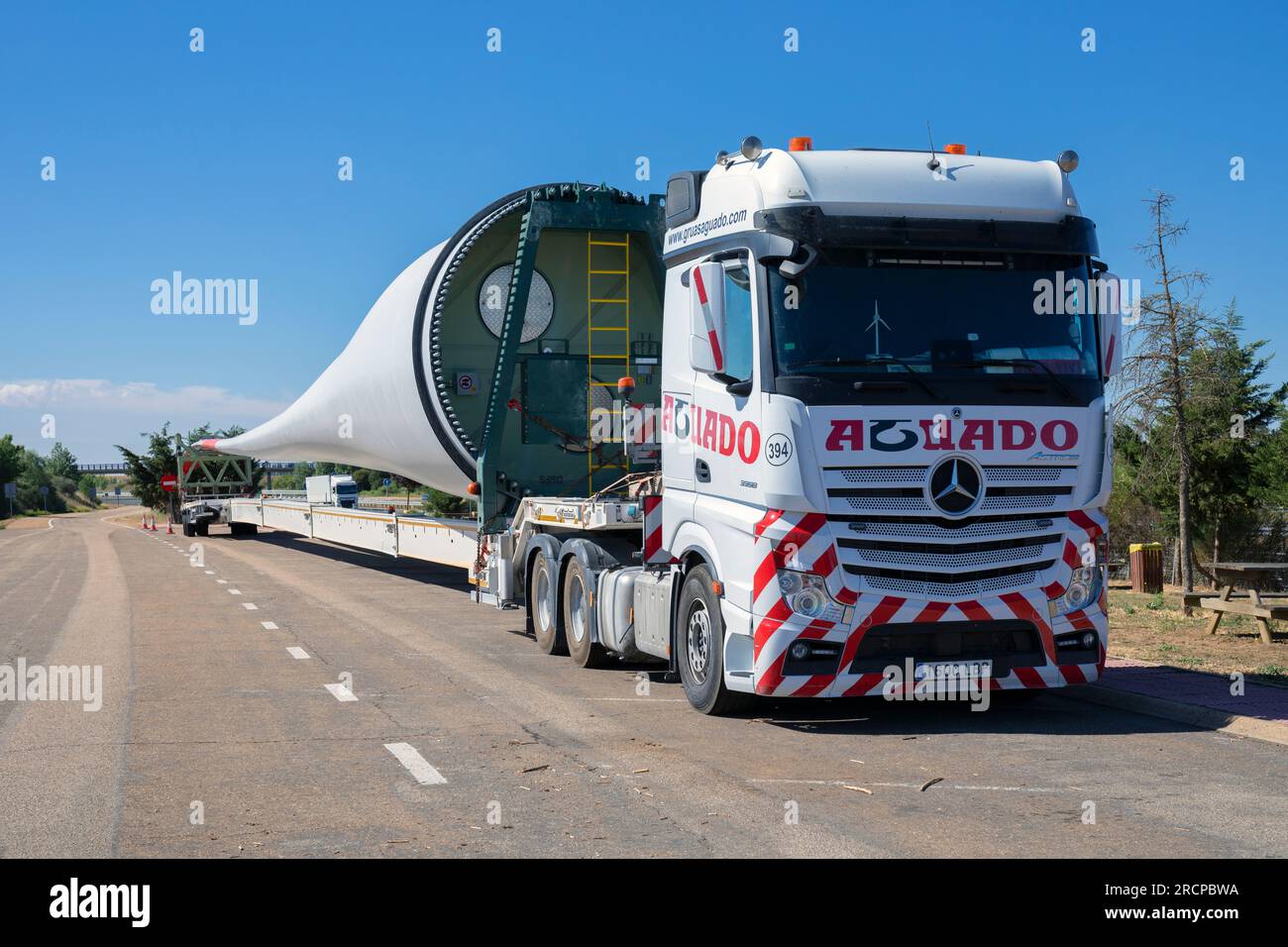 Europa, Spanien, Kastilien und León, Abia de las Torres Motorway Services, Lastkraftwagen mit großem Schild für den Bau einer neuen Horizontalachse-Windkraftanlage Stockfoto