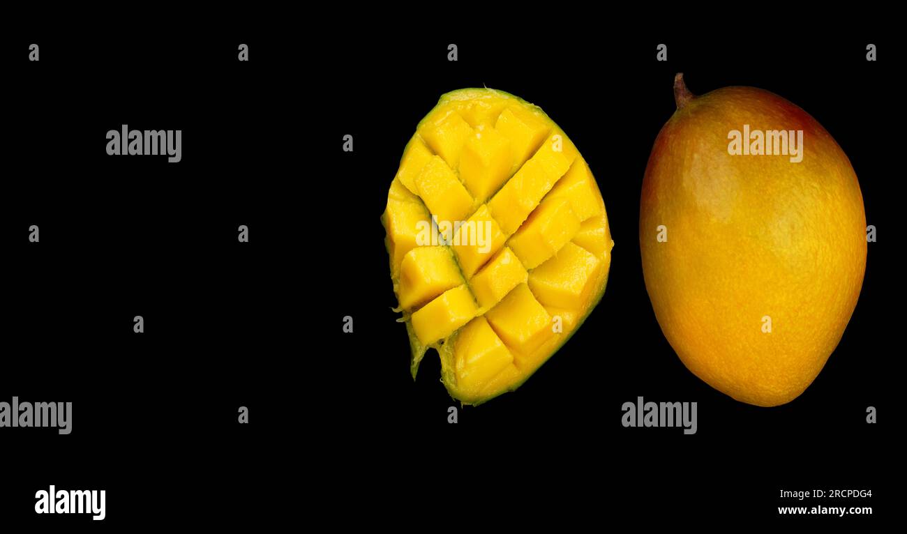 Ganze Mango-Früchte und geschnittene Hälfte der Mango isoliert auf schwarzem Hintergrund, Draufsicht Stockfoto