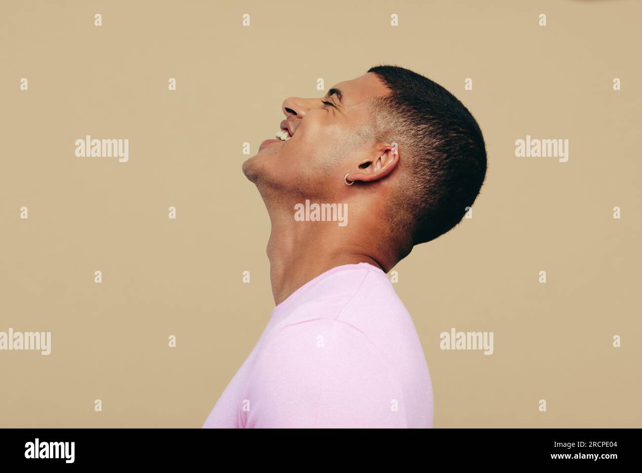 Attraktiver junger Mann, der lächelt, während er seinen strahlenden, jugendlichen Hautton zeigt. Seine Hingabe zur Hautpflege und Pflege ist offensichtlich, und sein Engagement für sich selbst. Stockfoto