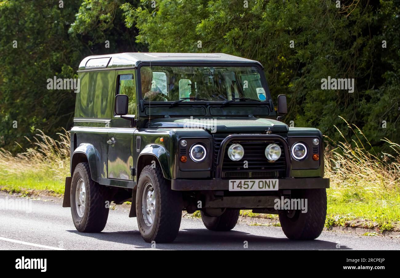 Milton Keynes, Großbritannien - Juli 16. 2023: 1999 grüner LAND ROVER DEFENDER, der auf einer englischen Straße fährt Stockfoto