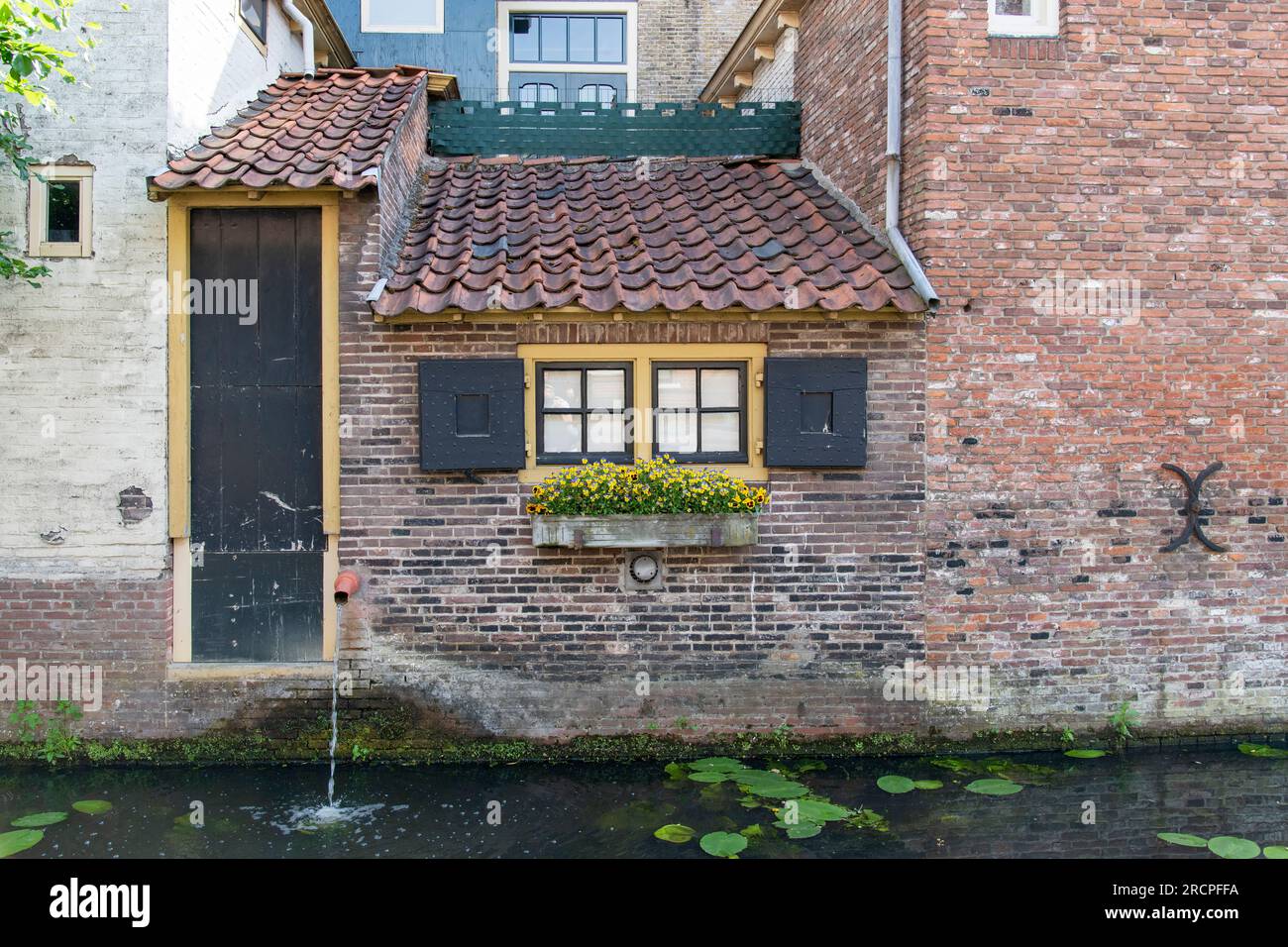Nahaufnahme der Hinterseite der Küche eines typischen Kanalhauses in den Niederlanden direkt am Wasser mit Tür und kleinen Fenstern mit Shutte Stockfoto