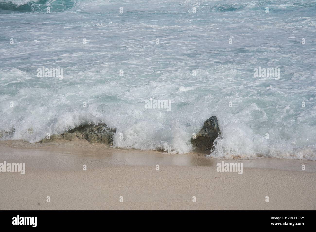 Wellen am Ufer, weißer Sandstrand und Korallenbett, Mahe Seychellen Stockfoto