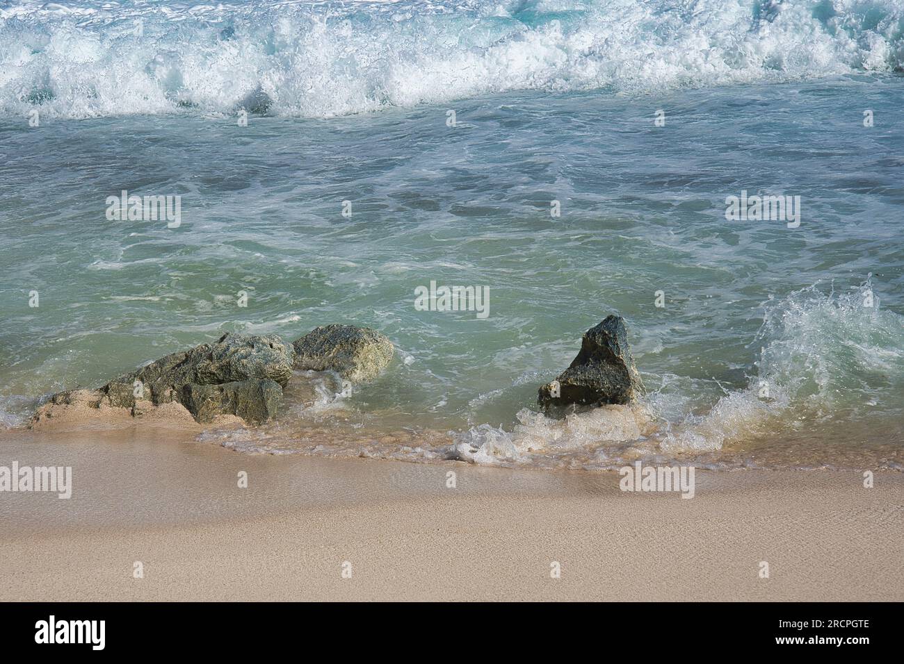 Wellen am Ufer, weißer Sandstrand und Korallenbett, Mahe Seychellen Stockfoto