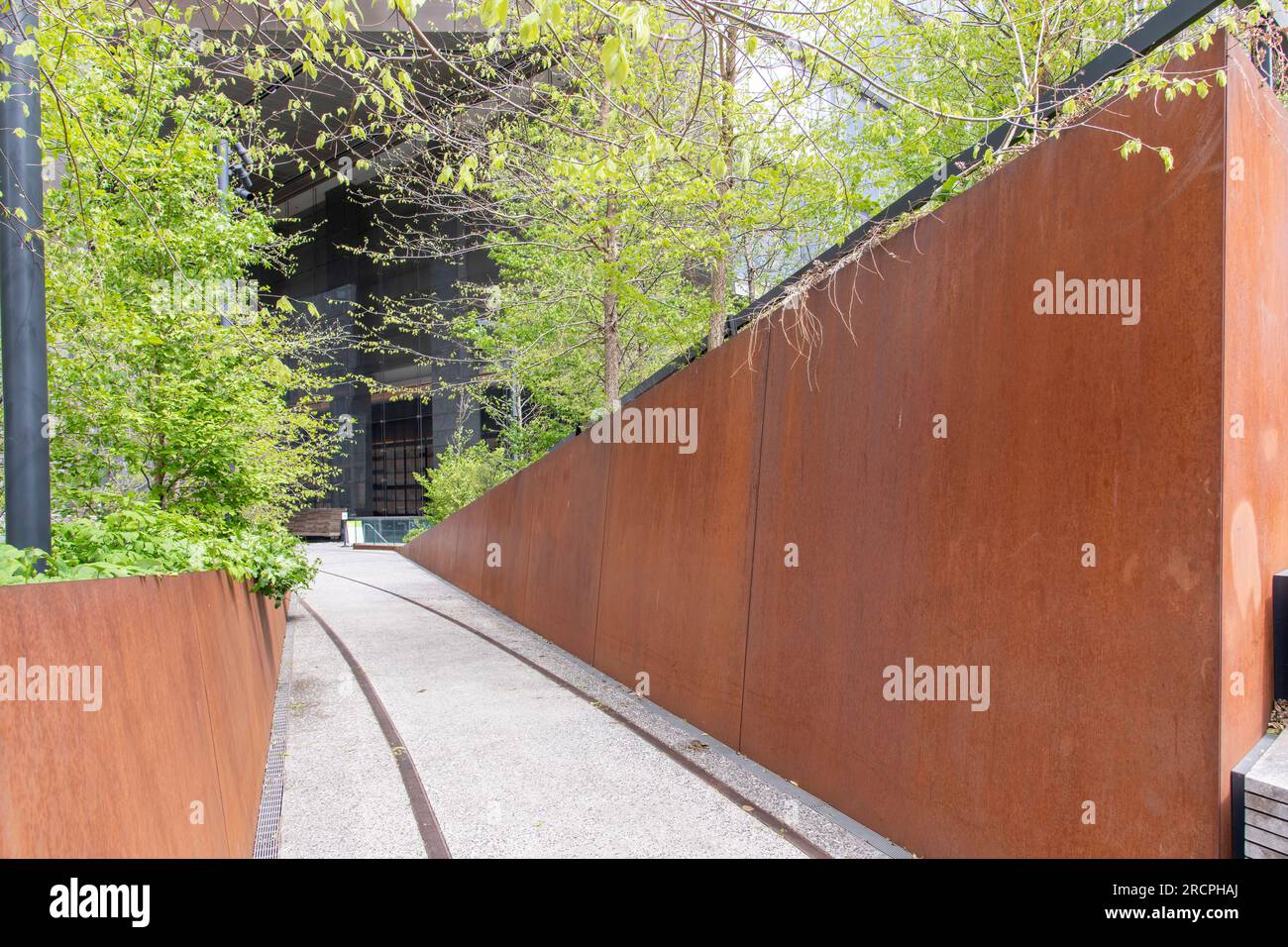 New York City, NY, USA – Juni 2022; Blick auf die kortenförmigen oder verwitterten Stahlwände im modernen Hochglanzpark der High Line mit Fußweg und alten Eisenbahnschienen n Stockfoto