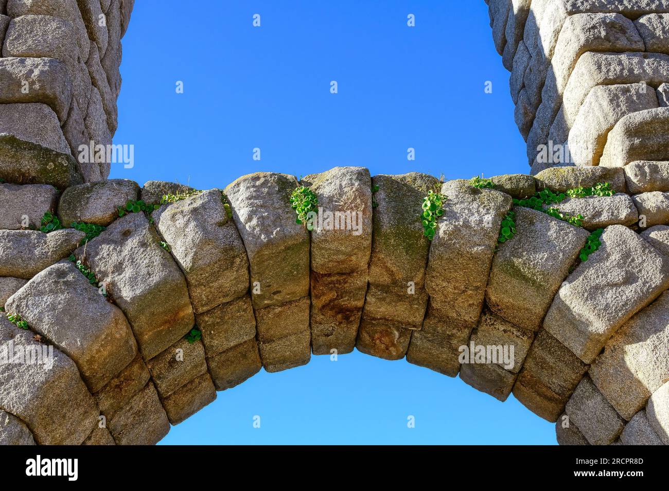 Segovia, Spanien - 11. Februar 2023: Römisches Aquädukt. Nahaufnahme eines Steinbogens im historischen Gebäude. Ziegelverlegungstechnik vergangener Zeiten. Stockfoto