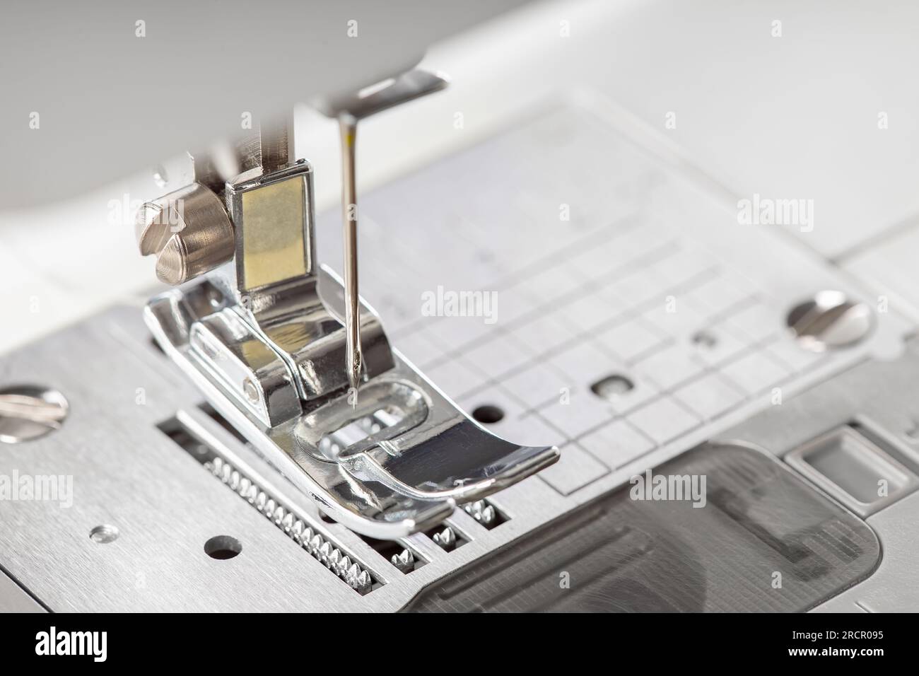 Moderne, weiße Nähmaschine, Presser, Fußnaht, Makro. Nähausrüstung, Arbeitsgerät für Ateliergeschäft, Fertigung, Beruf. Stockfoto