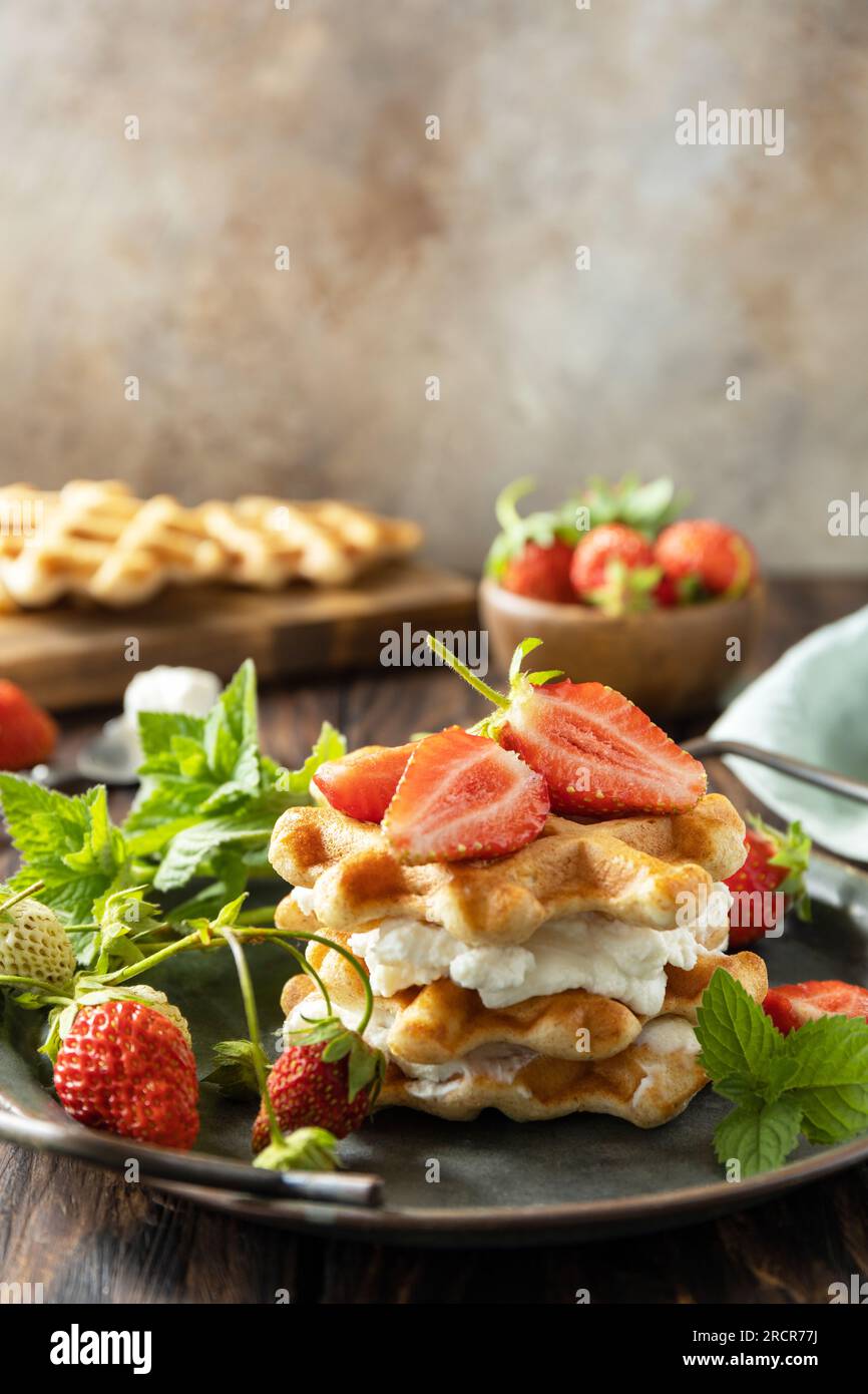 Belgische Waffeln mit frischen Berrie-Erdbeeren und Ricotta-Käse zum Frühstück auf einem rustikalen Tisch. Speicherplatz kopieren. Stockfoto