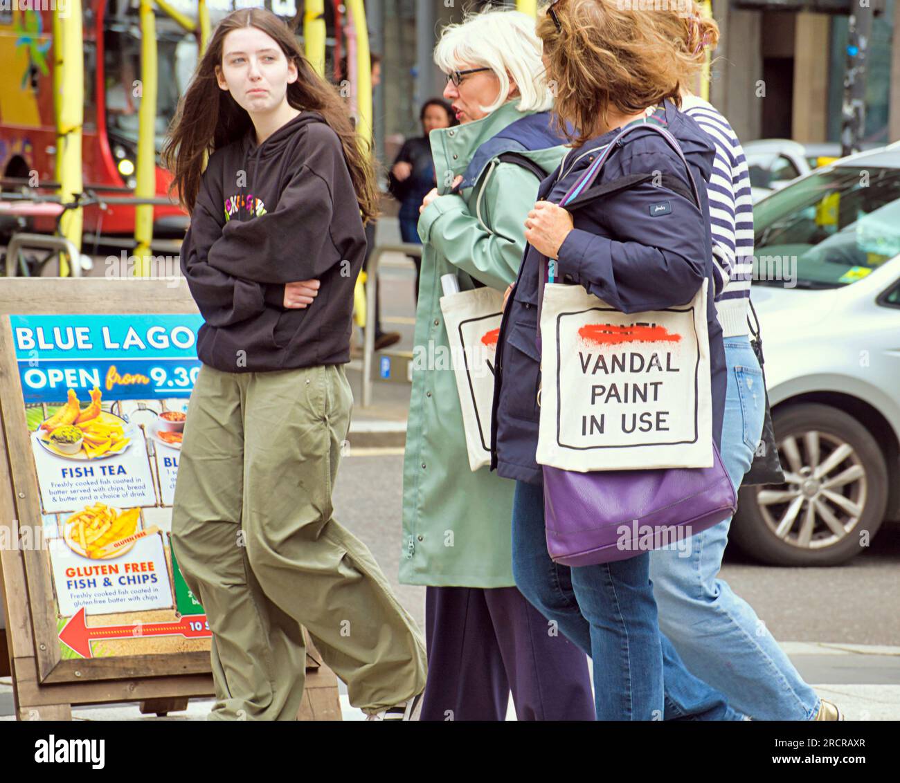 Glasgow, Schottland, Vereinigtes Königreich 16. Juli 2023. Die Tragetasche der Ausstellung hat die Stadt befallen. Besucher vor dem Museum für moderne Kunst auf der banksy-Ausstellung . In Glasgow wird "New Banksy" oder "Wanksy" genannt, da ihre Authentizität an derselben Stelle in Frage gestellt wird wie jene, die vor einigen Wochen eine solche Kontroverse ausgelöst hat, eine Schablone zwischen den Postratten-Graffiti in der Nähe der aktuellen Ausstellung von Cut and Run. Credit Gerard Ferry/Alamy Live News Stockfoto