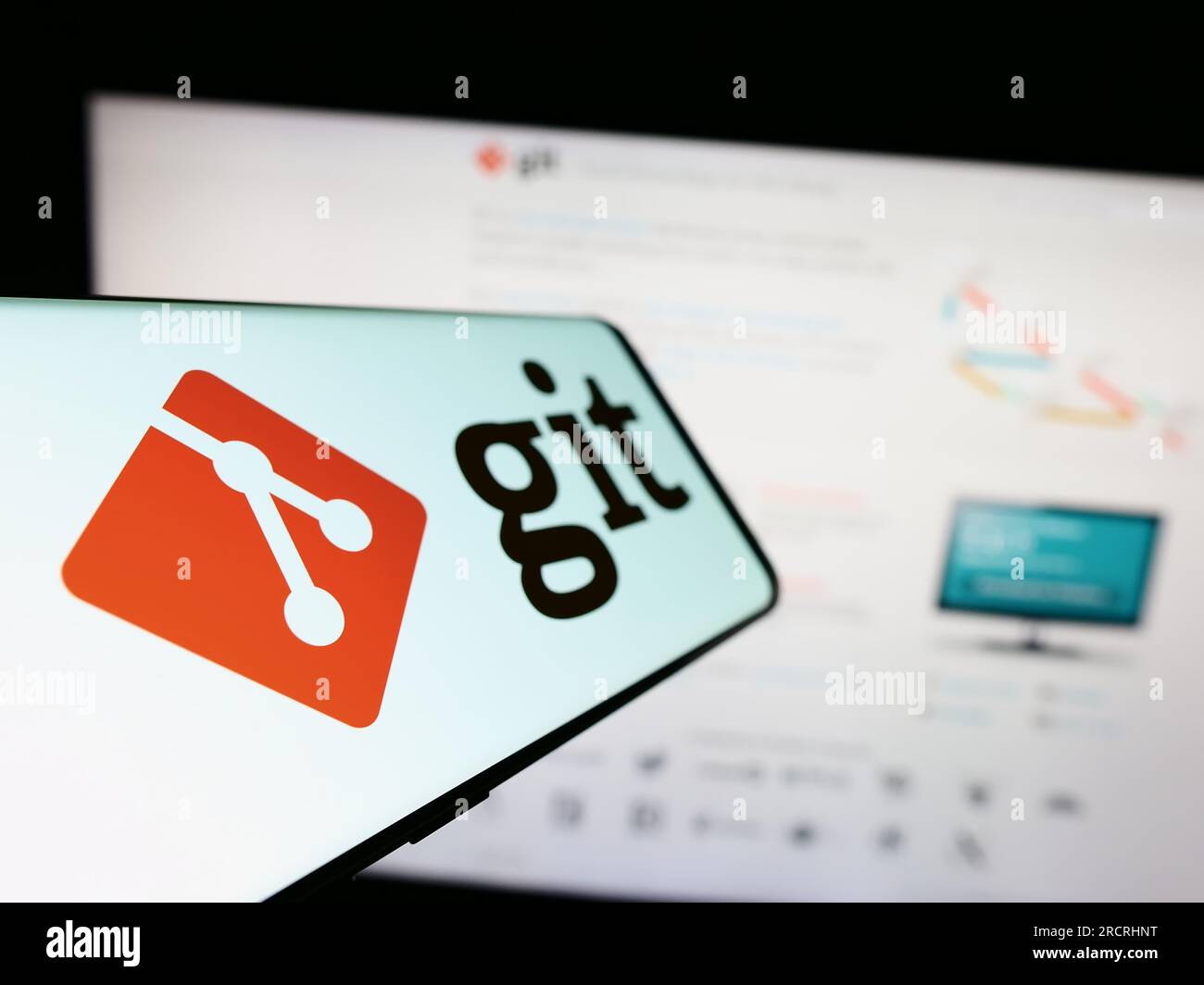 Mobiltelefon mit Logo des verteilten Versionskontrollsystems Git auf dem Bildschirm vor der Website. Fokus auf der linken Seite des Telefondisplays. Stockfoto