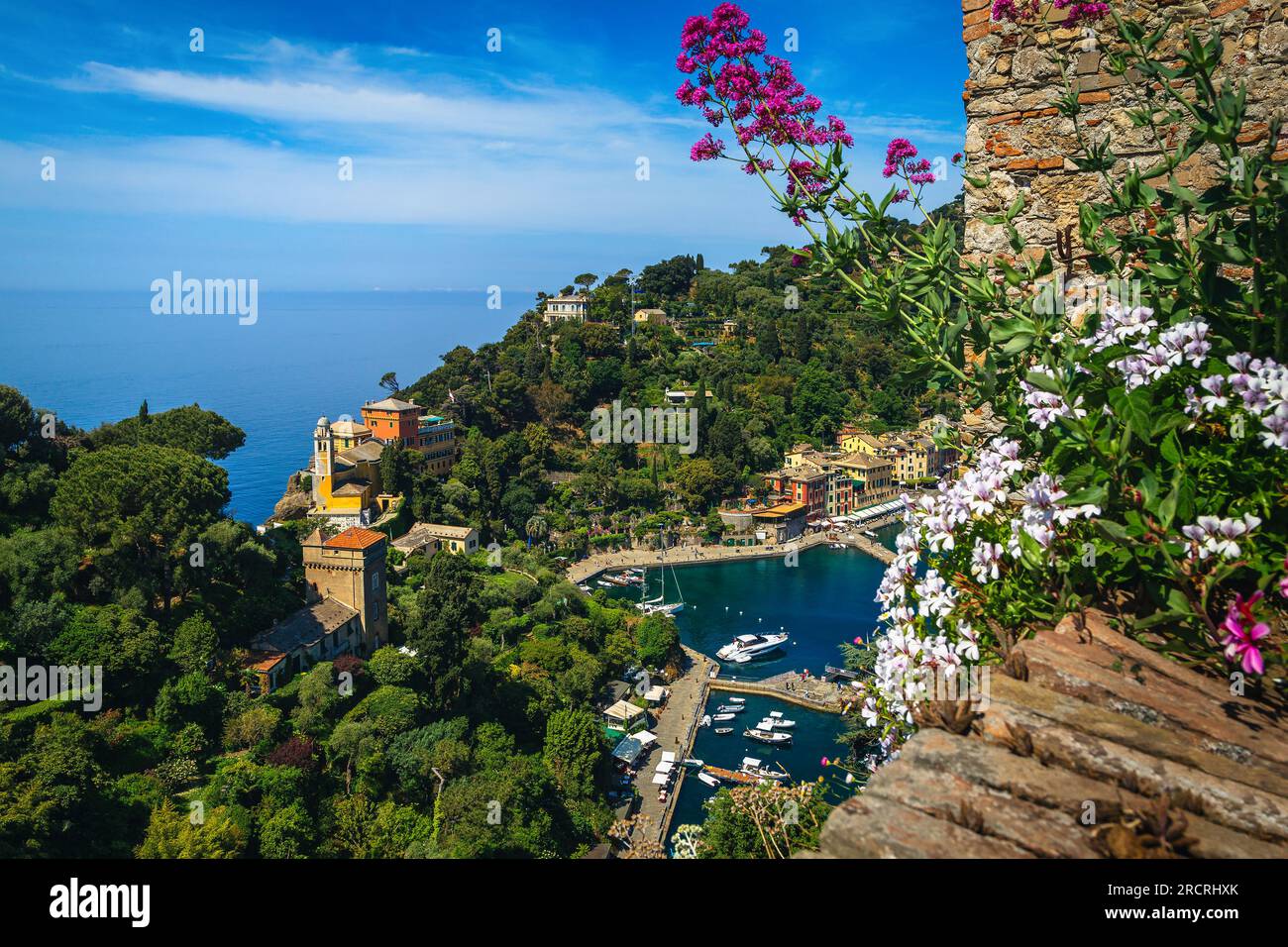 Toller Urlaub und tolle Reiselage in Ligurien. Blick auf das Portofino Resort mit bunten Gebäuden und Luxusbooten, Yachten von der blühenden Terrasse von Brow Stockfoto