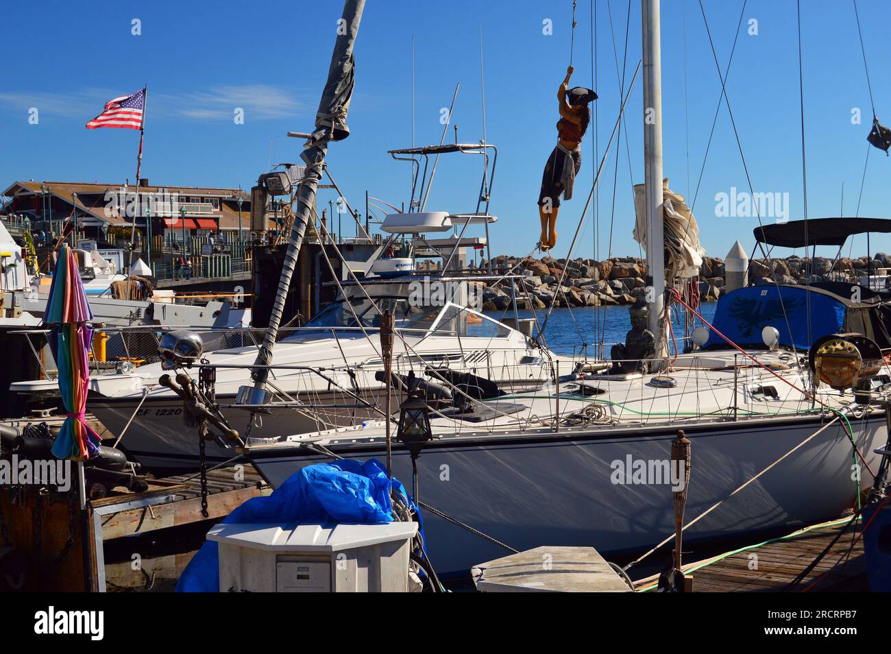 Am Mast eines Segelboots hängt eine Skulptur einer Piratenfrau in einem Yachthafen nahe Redondo Beach, Kalifornien Stockfoto