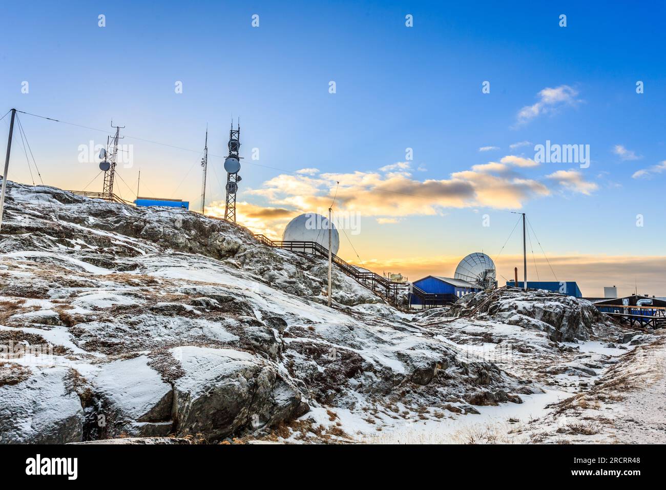 Arktische Telekommunikationsstation bei Sonnenuntergang zwischen Schneesteinen, Nuuk, Grönland Stockfoto