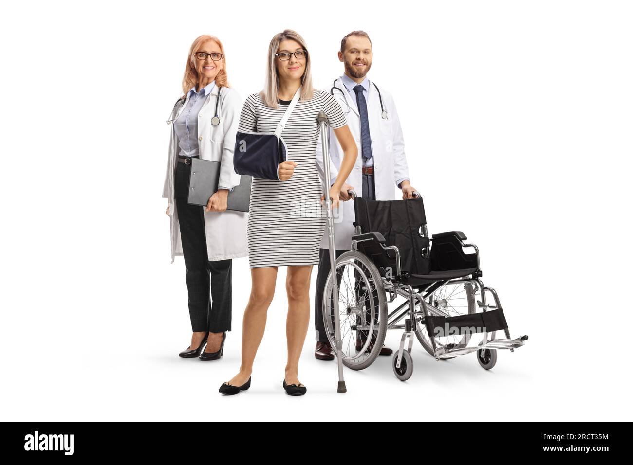 Ärzte stehen hinter einer Patientin mit einer Armschlinge und einer Krücke isoliert auf weißem Hintergrund Stockfoto
