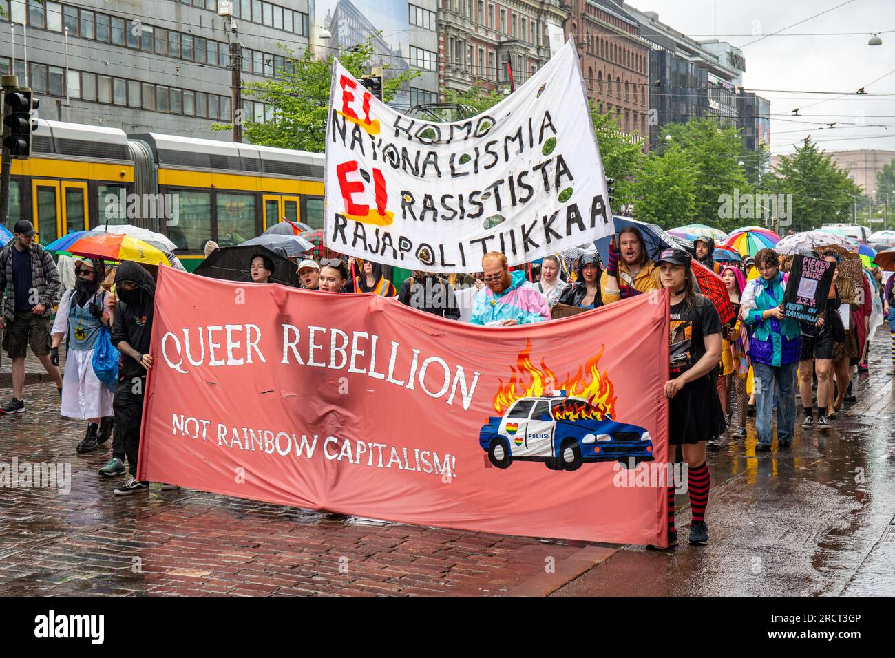 Bei Regen marschieren Menschen und tragen das Banner „Queer Rebellion“ bei der Helsinki Pride 2023 Parade in Helsinki, Finnland Stockfoto