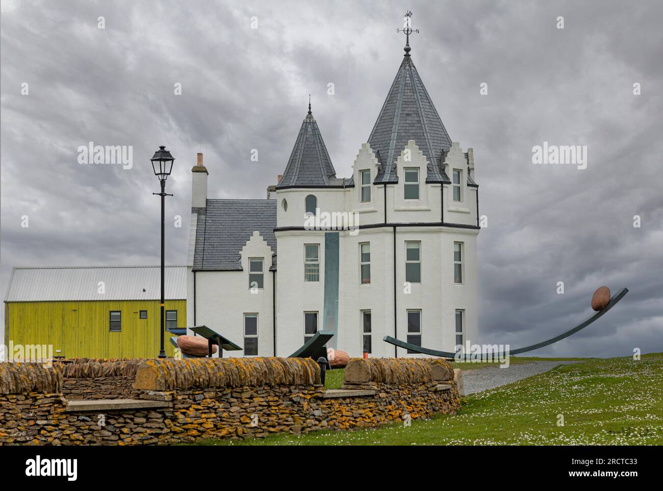 John O'Groats, Mai 7. 2023 - Schottland, Großbritannien - Weißes Hotel mit spitzem Dach am John O'Groats mit Balanced Stones Aerchitecture Stockfoto