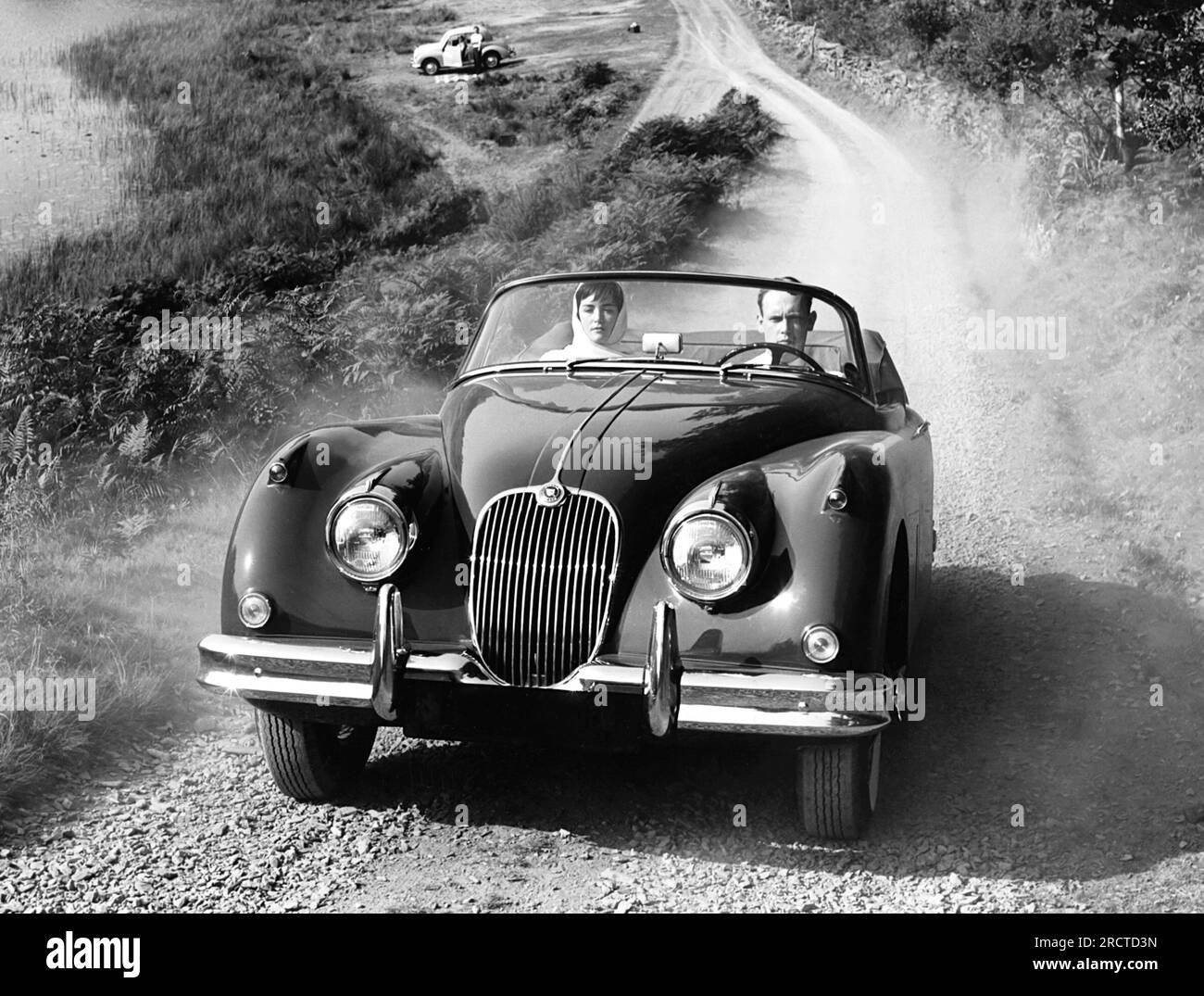 USA: 1958 Ein Paar fährt mit einem Jaguar XK 150-Coupé mit 1958-mm-Abzweigkanal durch das Land Stockfoto