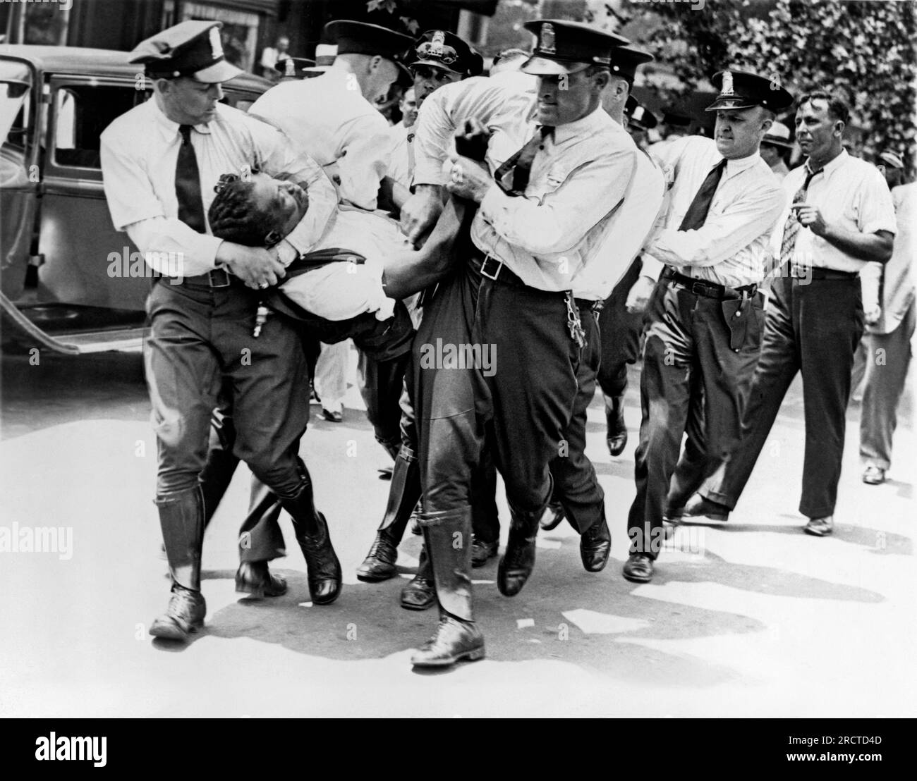 Washington, D.C.: 28. Juli 1932. Polizisten, die einen Veteranen aus dem 1. Weltkrieg, Mitglied der Bonus Expeditionary Forces, aus einem Gebäude auf der Pennsylvania Avenue während der Unruhen trugen, die durch einen Räumungsbescheid ausgelöst wurden. Stockfoto