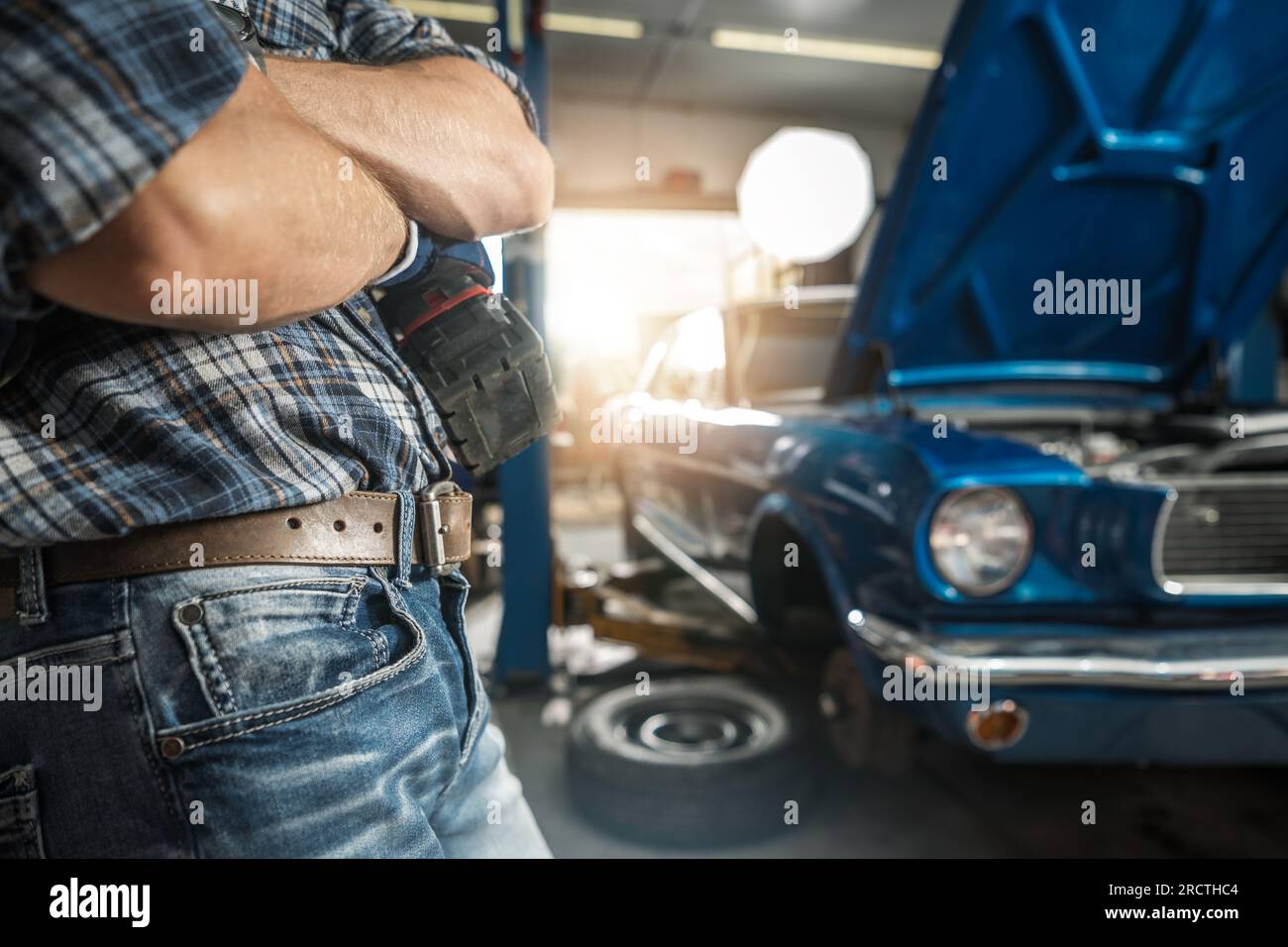 Konzeptfoto des Classic Cars Restoration Project mit Mechaniker und seinem Classic Muscle Car Stockfoto