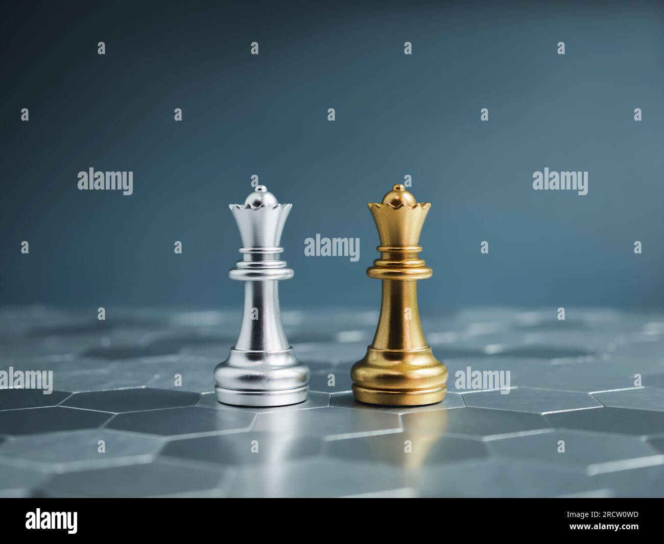 Goldene und silberne Queen-Luxusschachfiguren, die auf einem silbernen sechseckigen Schachbrett auf blauem Hintergrund stehen. Anführer, Freund, Feind, cooper Stockfoto