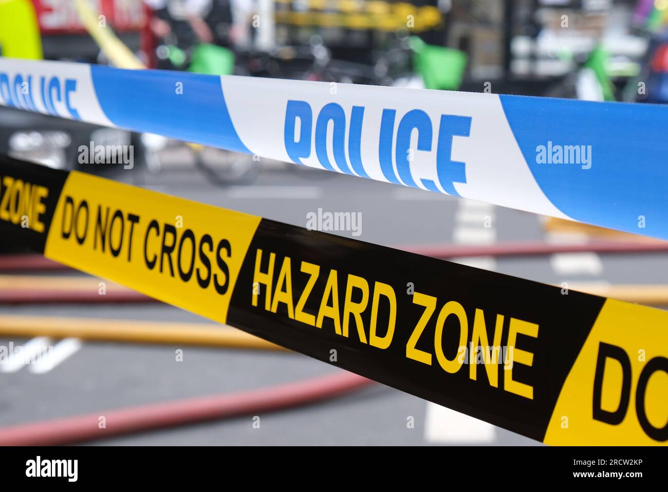 Britisches Polizeiband und Feuerwehr-Gefahrband, um einen Vorfall im Rettungsdienst abzuschirmen. Stockfoto