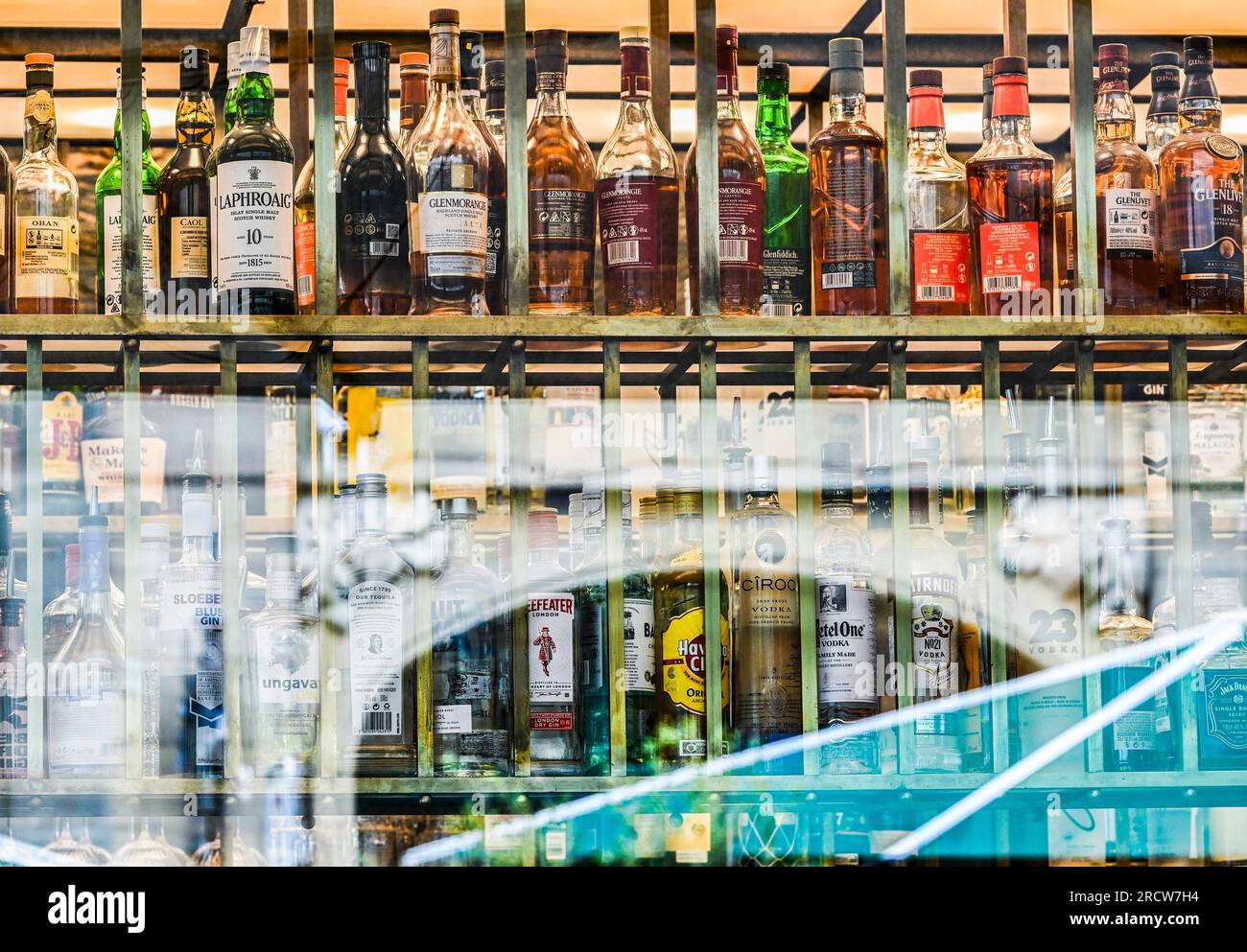 Berlin, Deutschland. 06. Juli 2023. Flaschen mit verschiedenen Arten von Alkohol sind hinter Fensterscheiben einer Bar zu sehen. Kredit: Jens Kalaene/dpa/Alamy Live News Stockfoto