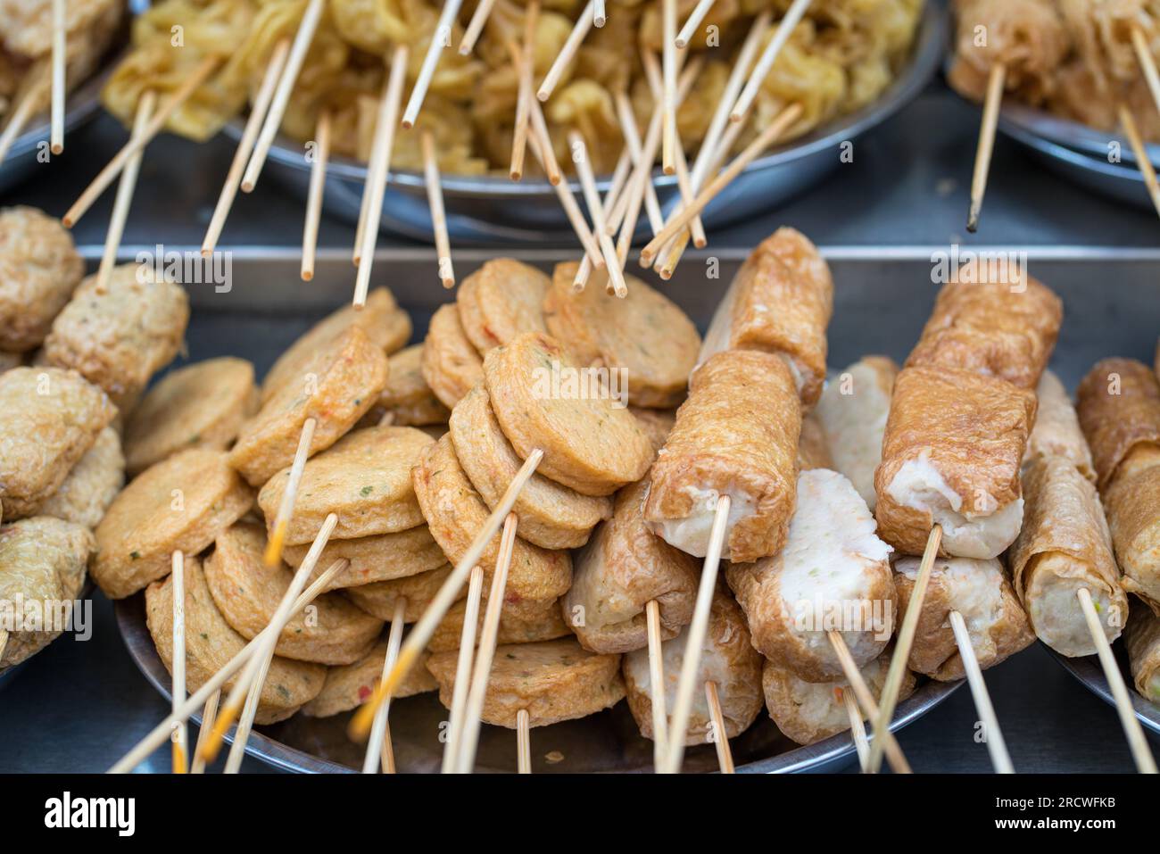 Asiatisches Street Food, Lok Lok, Fleisch- und Fischkuchen auf Spießen. Stockfoto