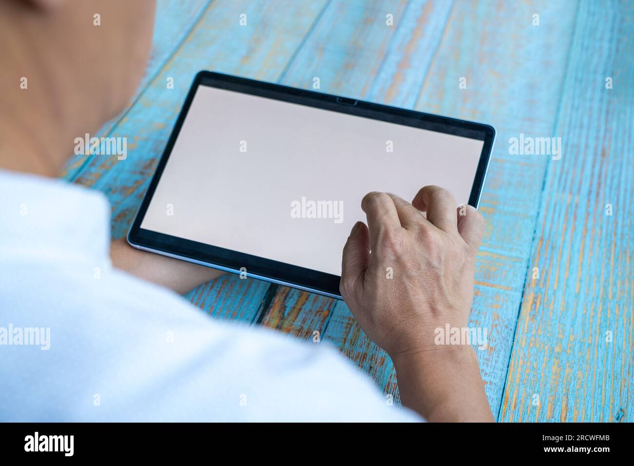 Mann, der ein digitales Tablet mit Touchscreen verwendet. Speicherplatz kopieren. Stockfoto