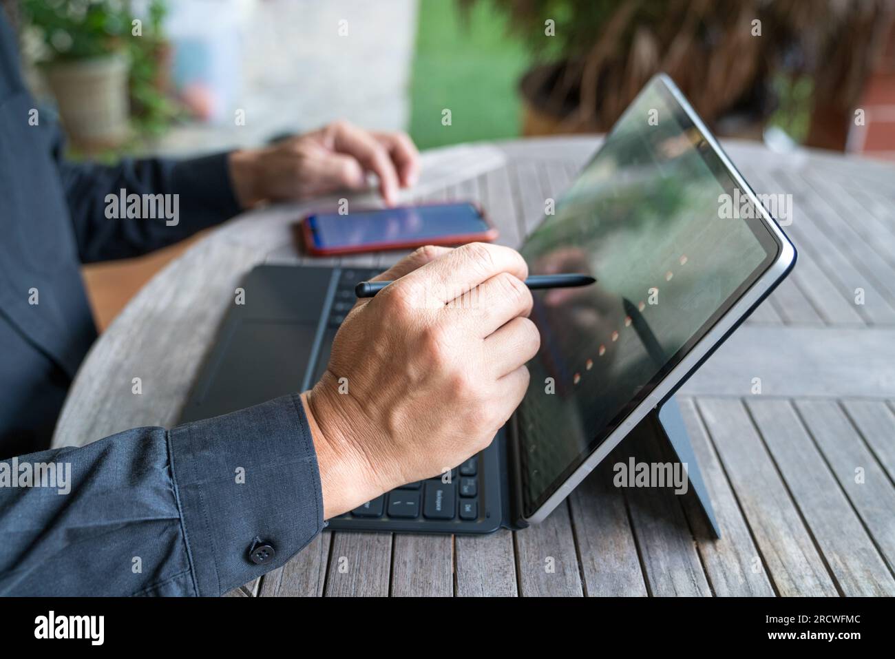 Geschäftsmann, der mit seinem Eingabestift an seinem Tablet arbeitet. Häusliche Umgebung. Stockfoto