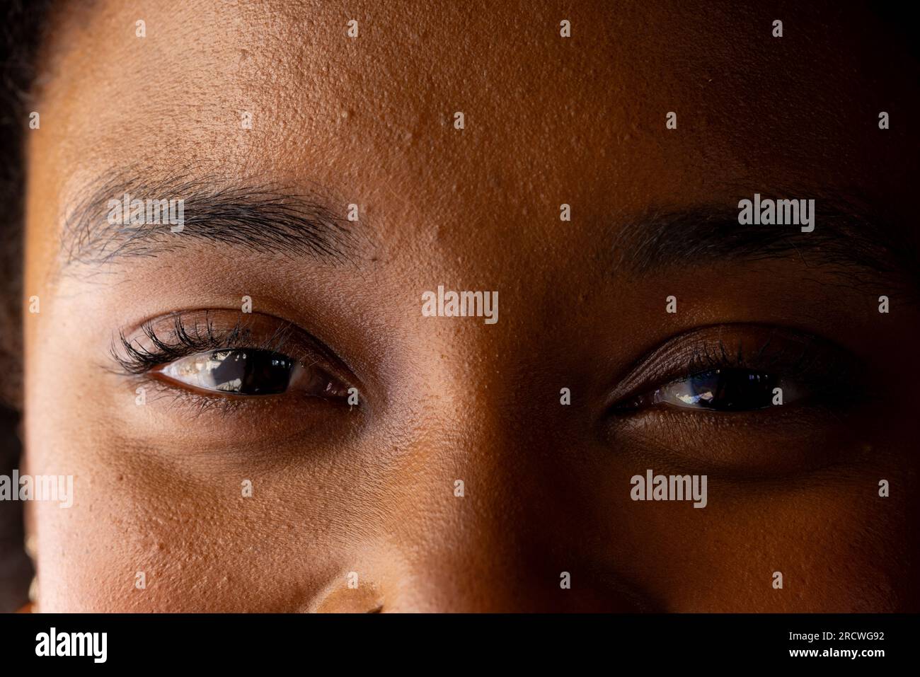 Porträtaufnahme der Augen einer afroamerikanischen Frau, die in der Sonne lächelt Stockfoto