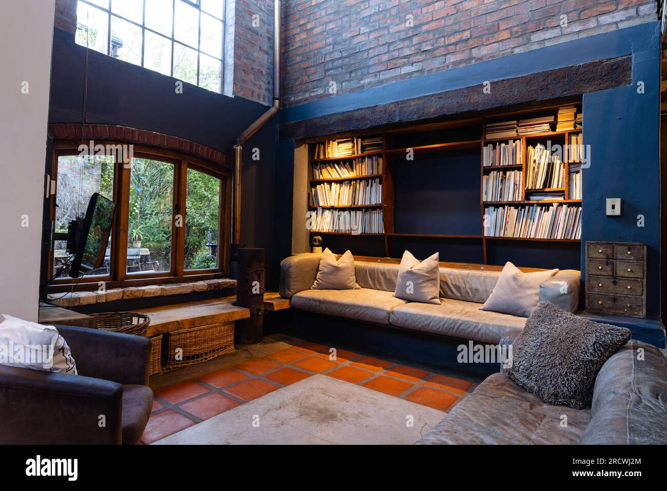 Allgemeiner Blick auf das Wohnzimmer mit Sofas, Sessel, Bücherregal und Fenster Stockfoto