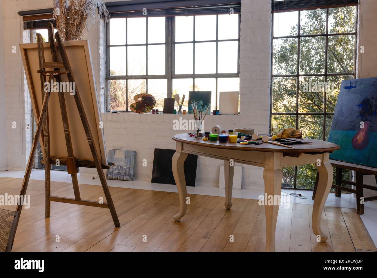 Allgemeine Ansicht des Heimstudios mit Staffelei und Tisch mit Malerausstattung Stockfoto