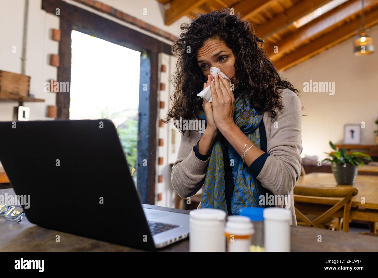 Birassische Frau, die auf der Arbeitsfläche sitzt und den Laptop für die medizinische Beratung benutzt Stockfoto