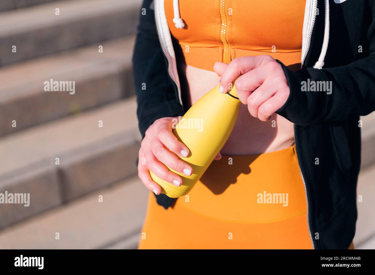 Sportflasche Wasser in den Händen eines Läufers Stockfoto