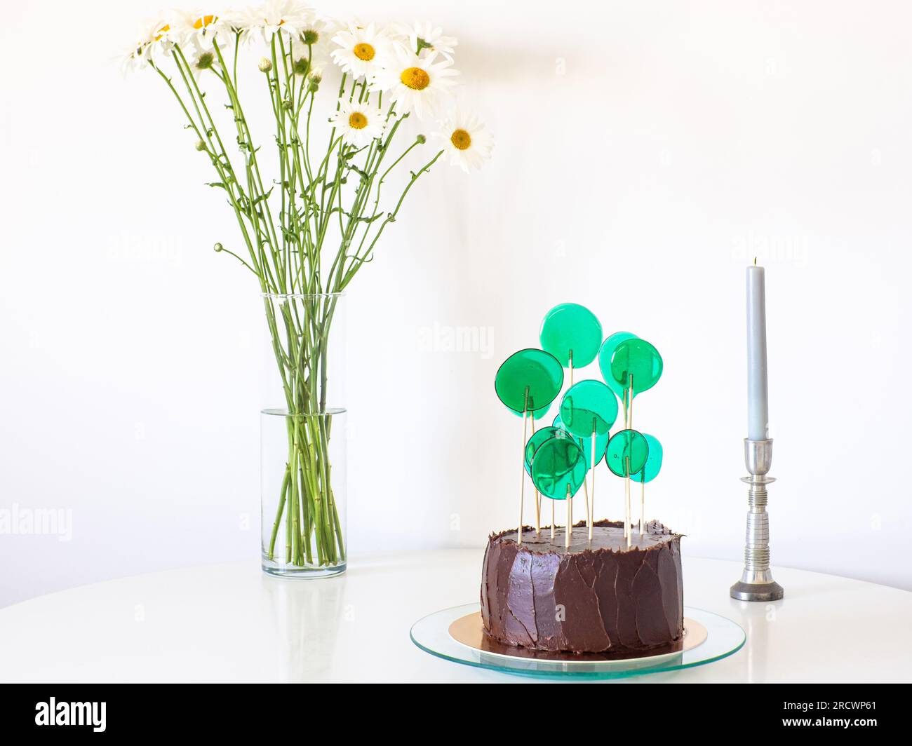 Schokoladenkuchen mit grünen Süßigkeiten auf weißem Hintergrund Stockfoto