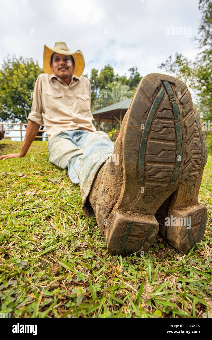 Der Cowboy ruht auf Gras, die Stiefel zeigen nach oben Stockfoto