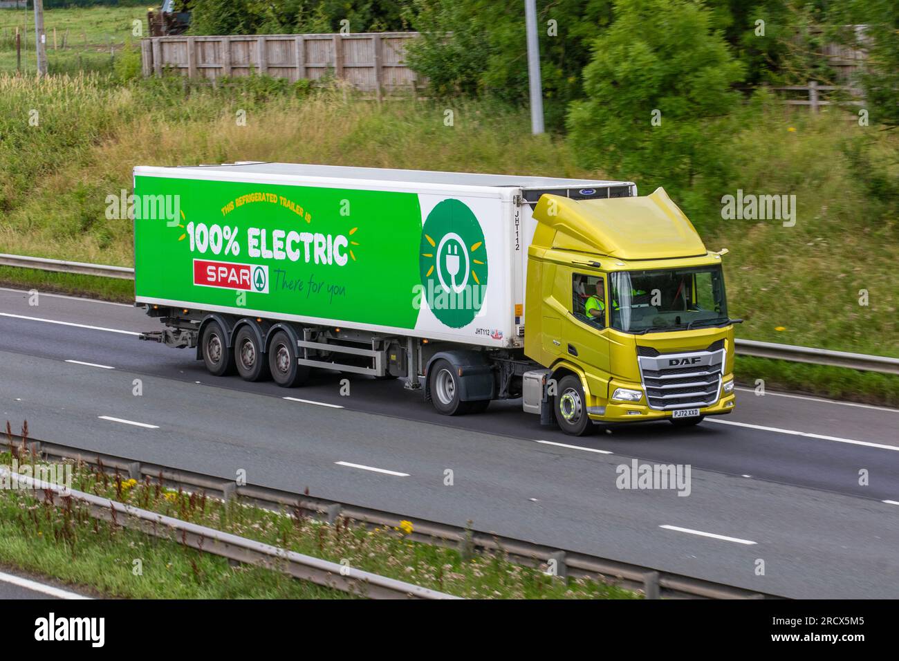 2022 Gelb, 100 % elektrisch, DAF CF Electric, zweiachsige Zugmaschine XO Spar Supermarkt, reinelektrischer Lkw. Ein 19-Tonnen-Elektra-e-Cargo-Kühlwagen, der mit hoher Geschwindigkeit auf der Autobahn M6 im Großraum Manchester, Großbritannien, fährt Stockfoto