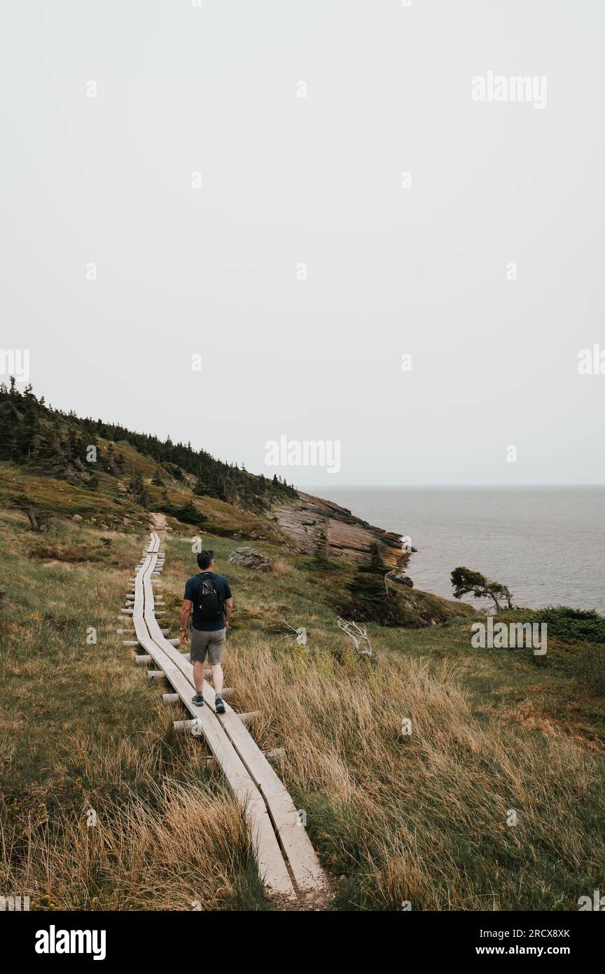 Wanderweg für Männer entlang der Küste von Neufundland an bewölkten Tagen. Stockfoto