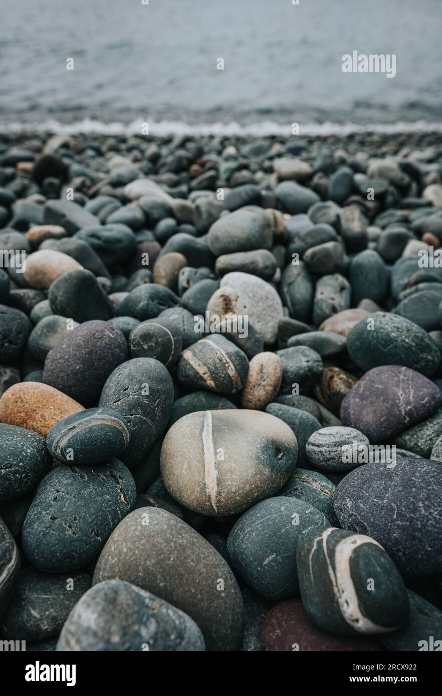 Nahaufnahme der farbenfrohen glatten Felsen am Strand in Neufundland, Kanada. Stockfoto