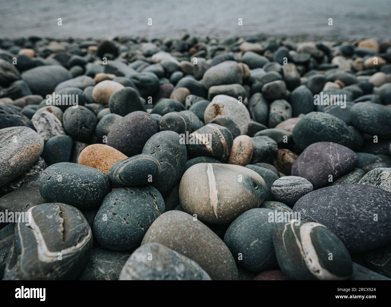 Nahaufnahme der farbenfrohen glatten Felsen am Strand in Neufundland, Kanada. Stockfoto