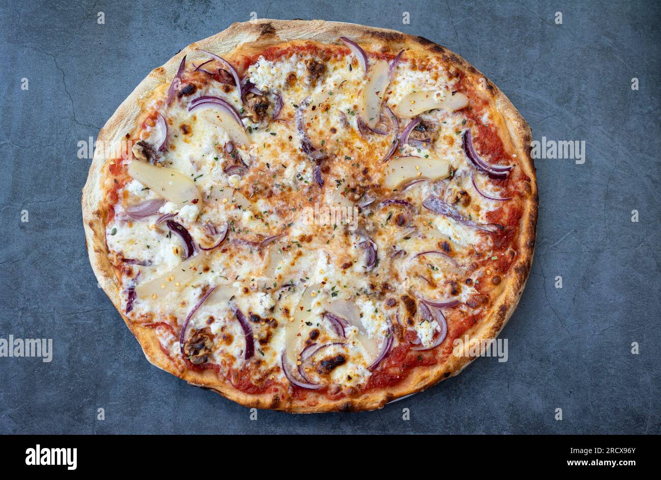 Italienische Spezialität Pizza mit Ziegenkäse, roten Zwiebeln, Honig und Walnüssen. Draufsicht Stockfoto