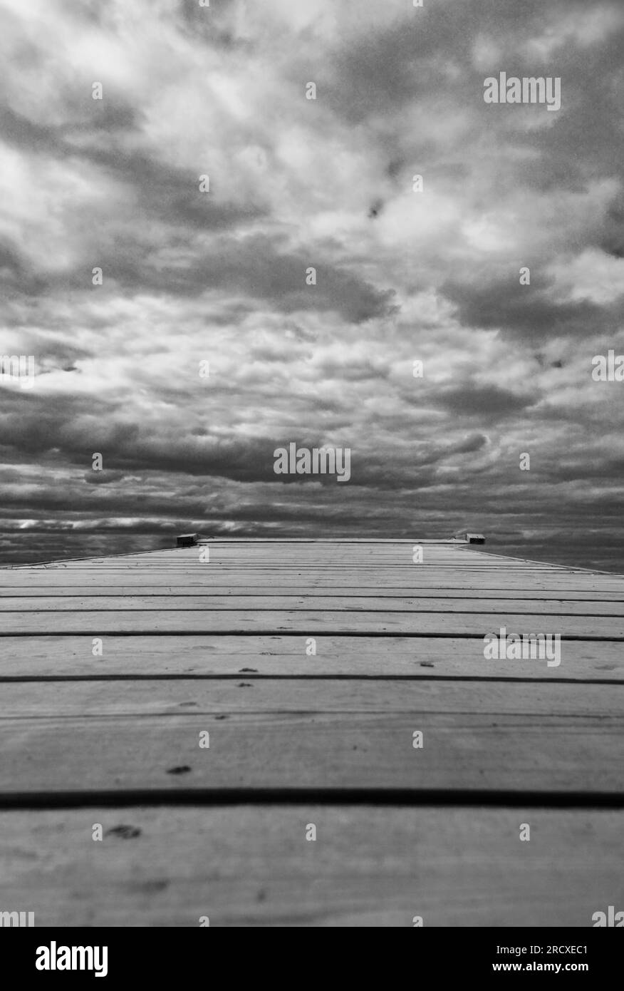 Hölzerner Pier gegen Sturmwolken, die auf dem Karenjarvi-See Kuhmo Finland liegen. Juni 2023. Stockfoto