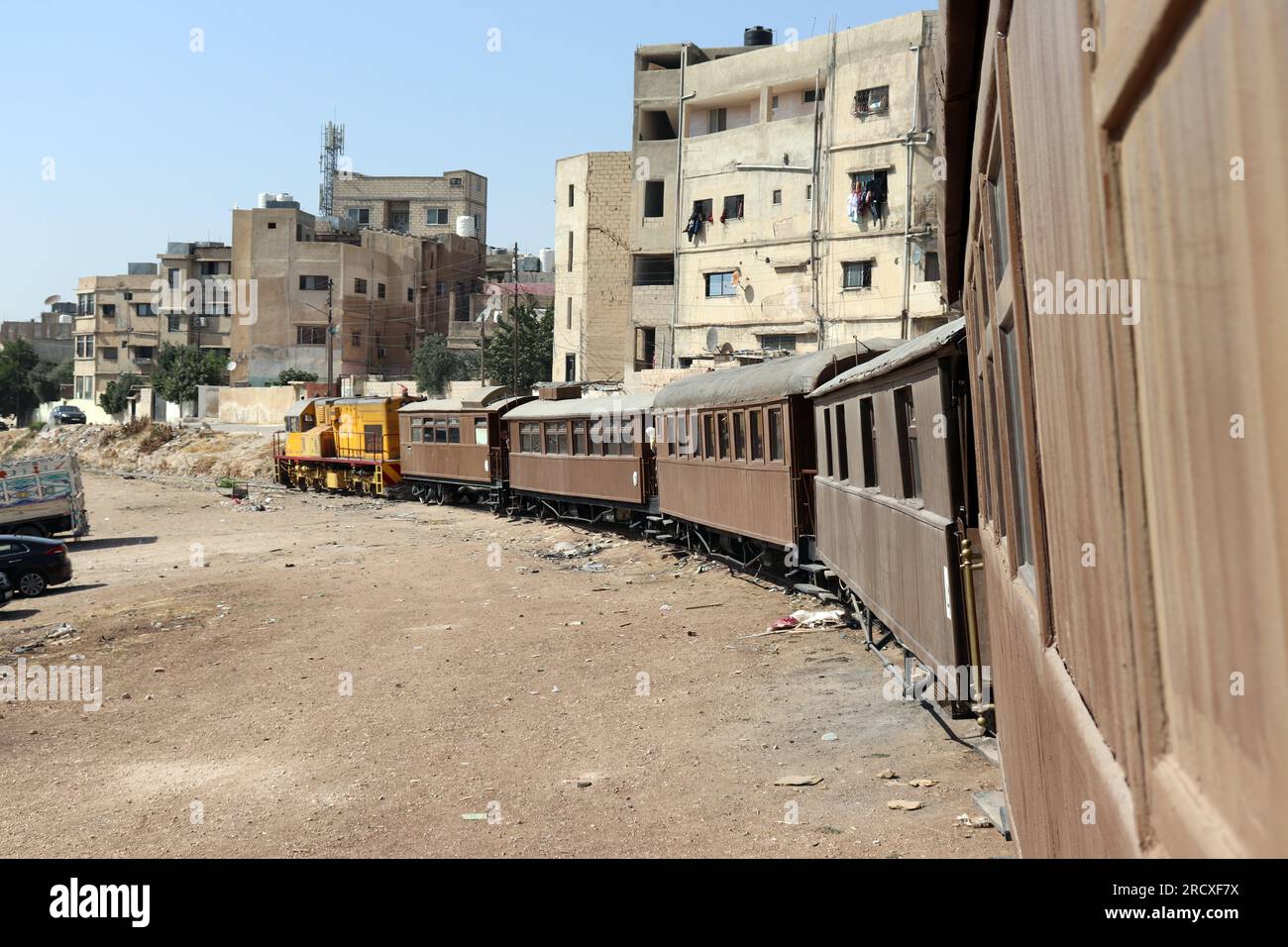 Ein Zug zwischen Häusern - eine alte türkische osmanische Dampfeisenbahn in Jordanien - Hedjaz Jordan Railway Stockfoto
