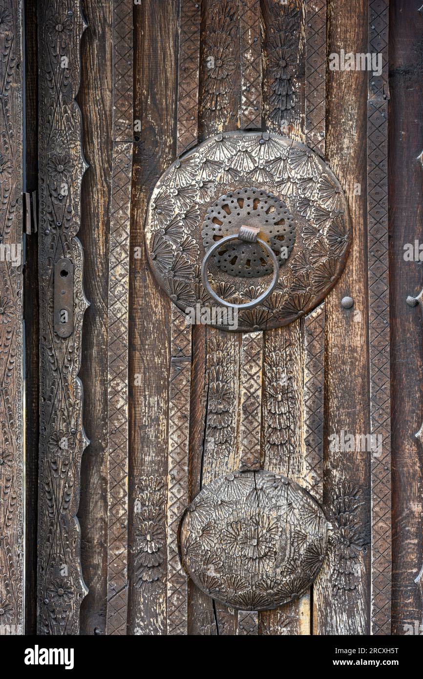 Eine dekorierte Holztür mit Eisengriff an einem Haus in der Altstadt von Jajce. Zentralbosnisch-Herzegowina, Balkanhalbinsel, Osteuropa. Stockfoto