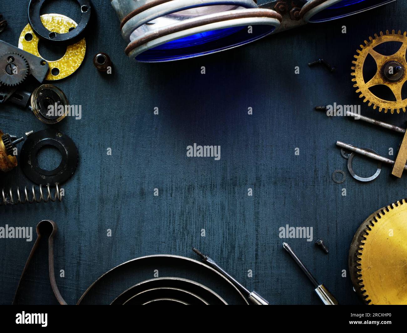 Draufsicht auf den Schreibtisch eines Handwerkers mit alten Zahnrädern und Mechanismen. Leerer Platz. Stockfoto