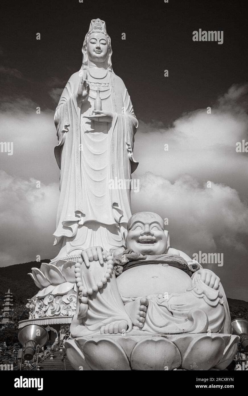 Eine Budai oder lachende BuddhaStatue vor der riesigen Statue von