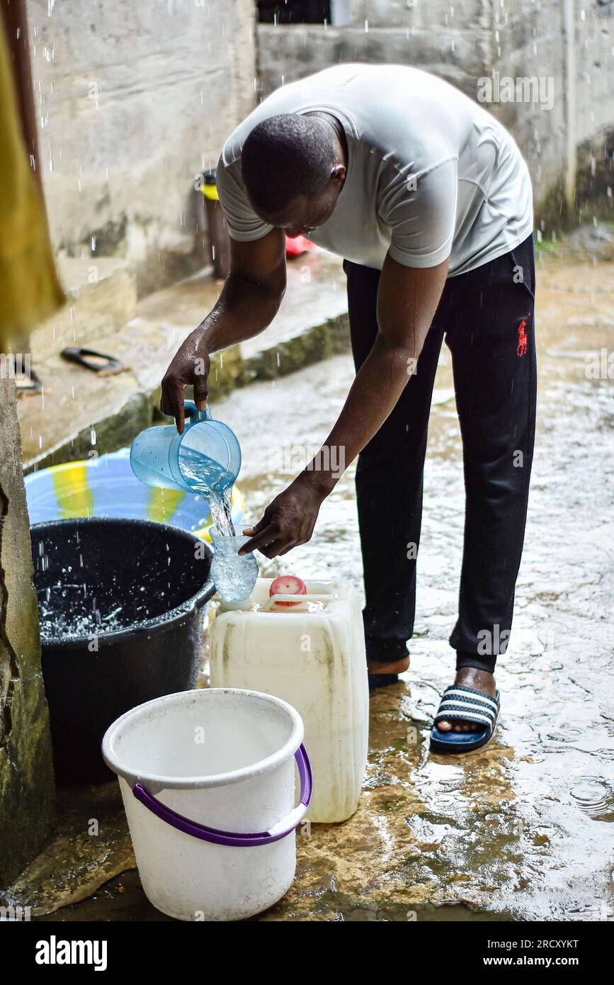 Ein malischer Mann, der Regenwasser vor seinem Haus in einem armen Viertel von Libreville mit Energie versorgt, 17. April 2022 Stockfoto