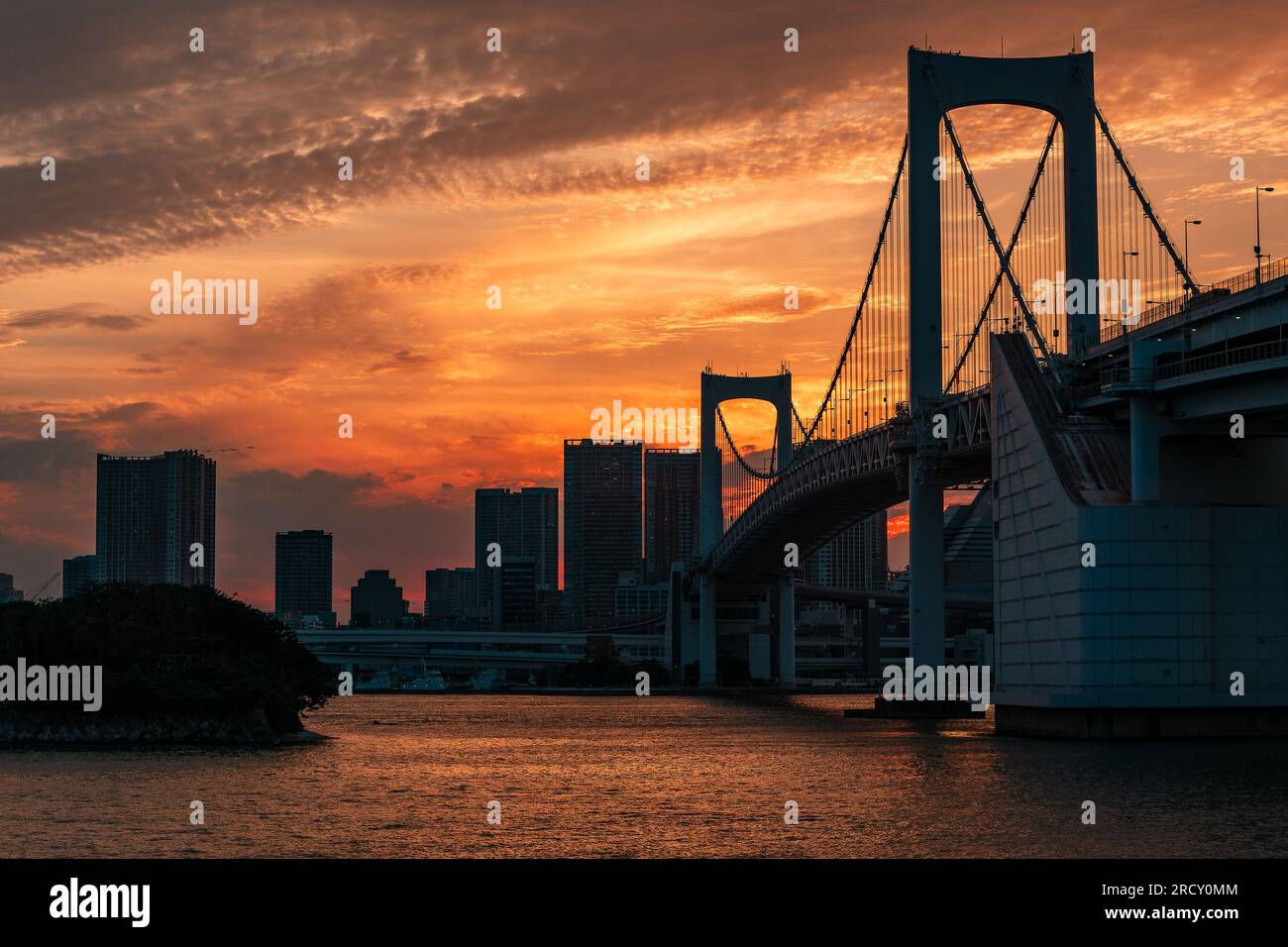 Ein lebendiger, farbenfroher Sonnenuntergang hinter den Wolkenkratzern von Tokio und der Rainbow Bridge Stockfoto