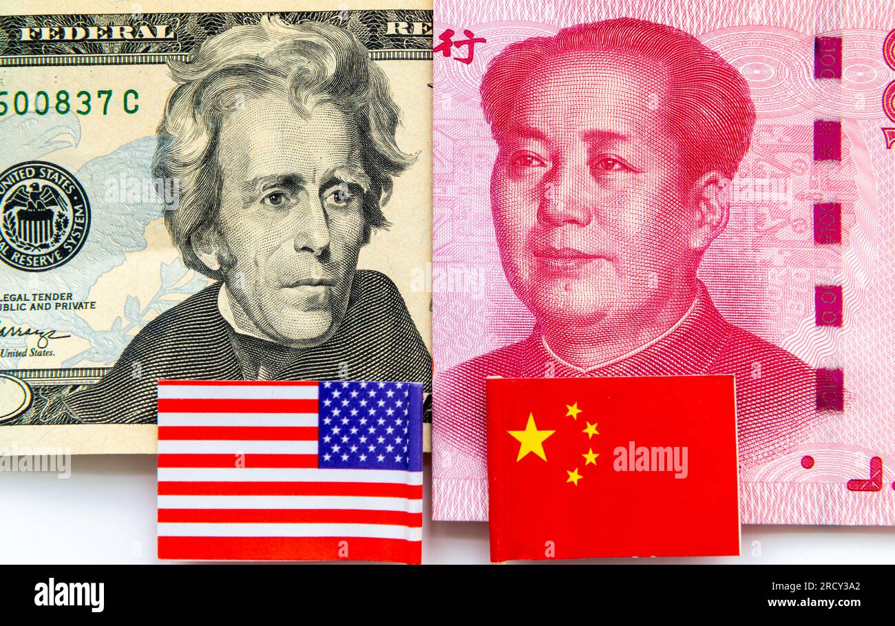 Ein 20-Dollar-Schein und ein chinesischer 100-Yuan-Schein, wobei die US-amerikanischen und chinesischen Nationalflaggen in Weiß isoliert sind. Internationale Finanz- und Handelskonkurrenz CO Stockfoto