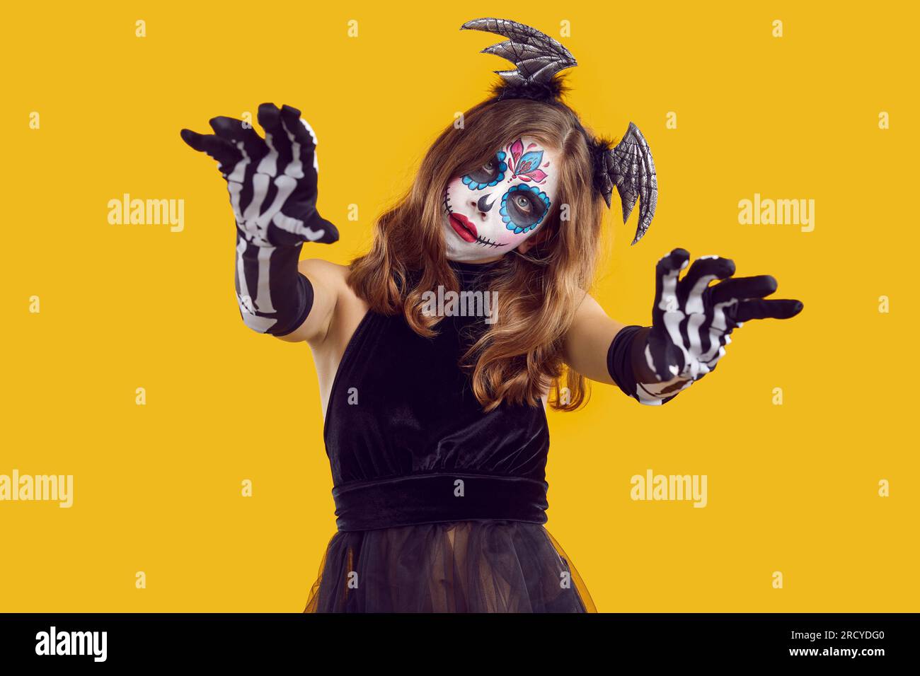 Das gruselige Teenager-Mädchen benimmt sich wie ein Zombie, der dich während der Halloween-Feier erschreckt. Stockfoto