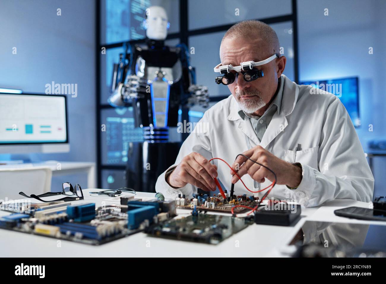 Reifer Ingenieur in Spezialbrille, der mit Computersystem am Tisch im Labor arbeitet Stockfoto